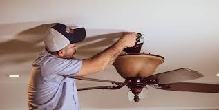 Electrician repairing ceiling fan