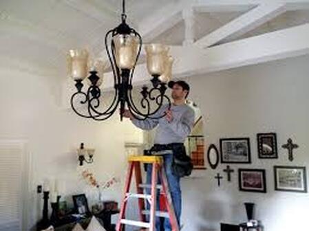 Electricians installing chandelear
